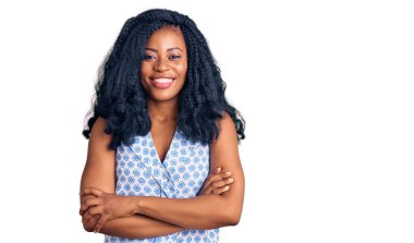 Güzel Afro-Amerikan kadın, günlük yazlık tişört giyip kollarını kavuşturup kameraya bakarken gülümsüyor. pozitif kişi. 