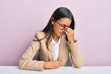 Ofiste çalışan güzel İspanyol kadın. Burnu ve gözleri ovuşturmaktan yorgun. Yorgunluk ve baş ağrısı çekiyor. Stres ve hüsran kavramı. 