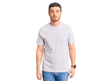 Ayılı yakışıklı genç adam rahat tişörtler giyiyor komik yüzlü yanakları şişiriyor. Havayla şişmiş ağız, çılgın bir ifade.. 