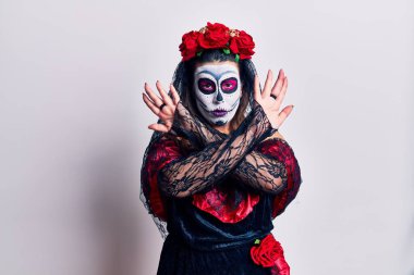 Ölü kostümü giymiş genç bir kadın beyaz reddedilme yüzünden kollarını kavuşturuyor ve avuç içleri negatif işaretler veriyor, kızgın bir yüz. 