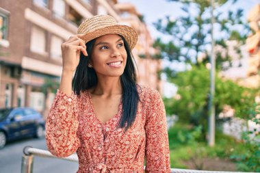 Genç Afro-Amerikan turist kadın tatilde gülümseyerek şehirde mutlu bir şekilde yürüyor..