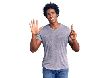 Yakışıklı Afro saçlı, sıradan giyinmiş, 6 numarayı gösterip gülümseyen, kendinden emin ve mutlu Afro-Amerikan adam.. 