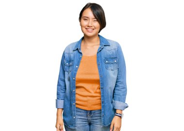 Kısa saçlı, sıradan bir kot ceket giyen genç, güzel İspanyol kadın kameraya seksi bir ifadeyle bakıyor, neşeli ve mutlu bir yüzle.. 