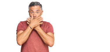 Sıradan kıyafetler giyen yakışıklı orta yaşlı bir adam yanlışlıkla elleriyle ağzını kapatırken şok oldu. gizli kavram. 