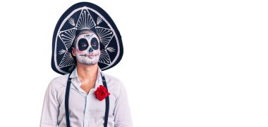 Arka planda ölü kostümü giymiş bir adam canlı yayında öpüşürken kameraya bakıyor. Sevimli ve seksi. aşk ifadesi. 