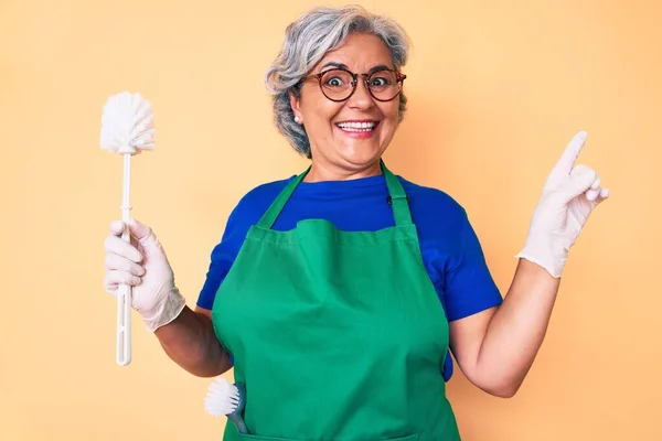 Mulher Hispânica Sênior Usando Avental Segurando Escova Sorrindo Feliz Apontando — Fotografia de Stock