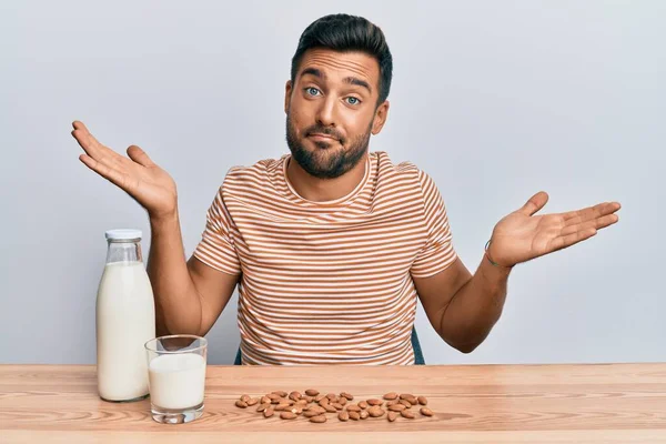 Handsome Hispanic Man Drinking Healthy Almond Milk Clueless Confused Open — Stock Photo, Image