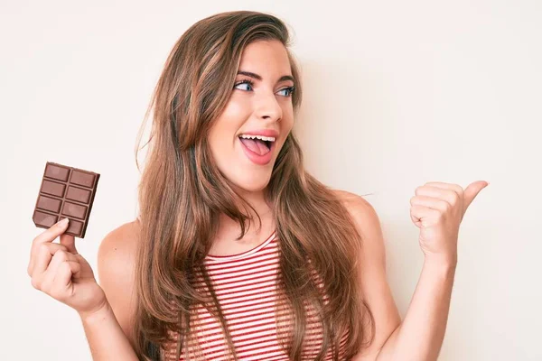 Hermosa Mujer Caucásica Joven Sosteniendo Chocolate Barra Cacao Apuntando Pulgar — Foto de Stock