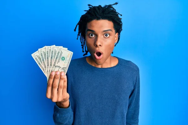 Young African American Man Holding Dollars Banknotes Scared Amazed Open — Foto de Stock