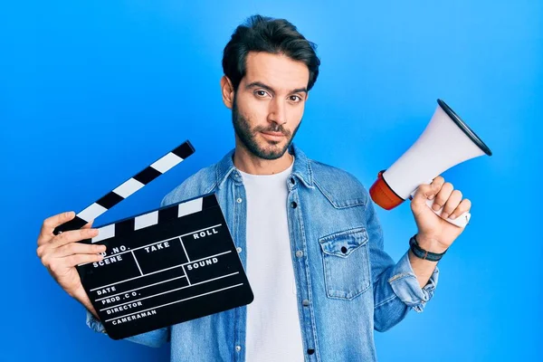 Giovane Uomo Ispanico Tenendo Video Pellicola Clapboard Megafono Rilassato Con — Foto Stock