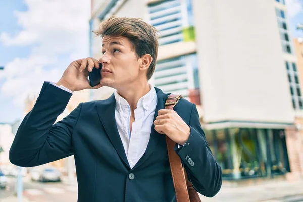 Kafkasyalı genç iş adamı ciddi bir ifadeyle şehirdeki akıllı telefondan konuşuyor..