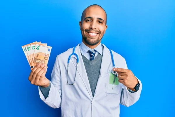 Ισπανόφωνος Ενήλικος Γιατρός Φορώντας Ιατρική Στολή Κρατώντας Χαρτονομίσματα Των Ευρώ — Φωτογραφία Αρχείου