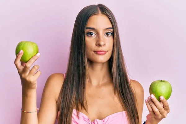 Junge Hispanische Frau Mit Grünen Äpfeln Entspannt Mit Ernstem Gesichtsausdruck — Stockfoto