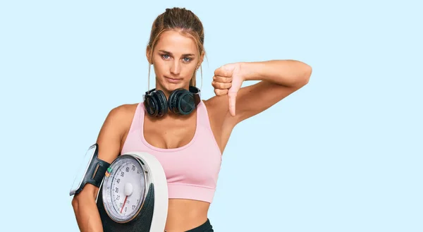 Jonge Blonde Vrouw Draagt Sportkleding Holding Weegmachine Met Boos Gezicht — Stockfoto