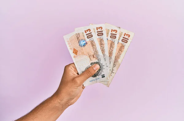 西班牙手拿着10英磅钞票 背景呈粉红色 — 图库照片