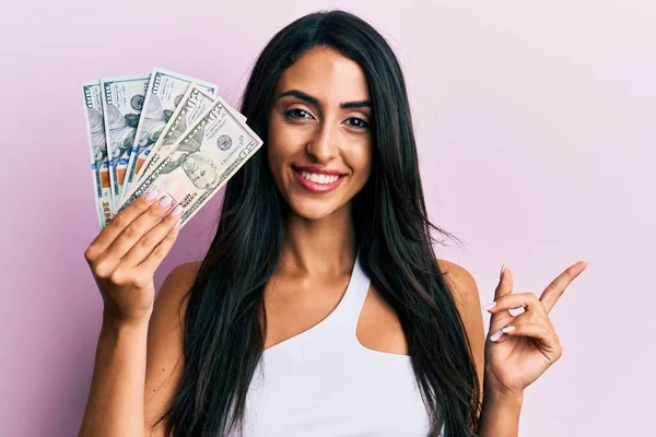 Beautiful Hispanic Woman Holding Dollars Smiling Happy Pointing Hand Finger — Stock Photo, Image