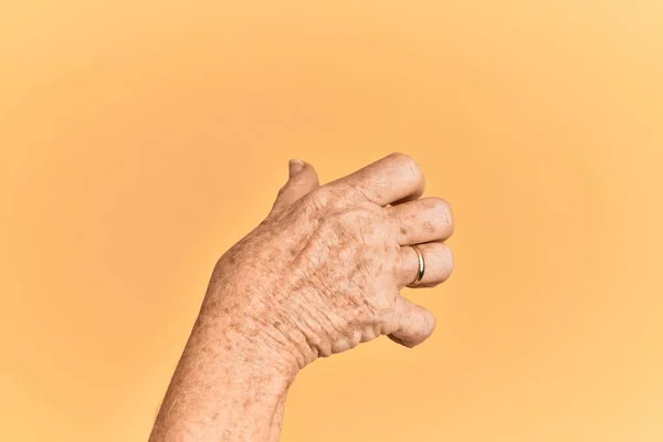 Senior Caucasian Hand Yellow Isolated Background Grasping Aggressive Scary Fingers — Stock Photo, Image