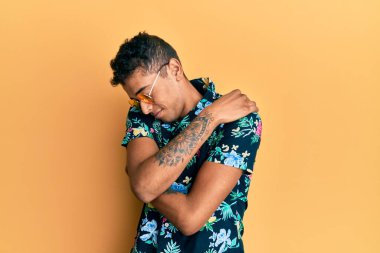 Genç, yakışıklı, afro-amerikalı, yaz tarzı giyinen, kendine sarılan, mutlu ve pozitif, kendinden emin. Sevgi ve özgüven. 