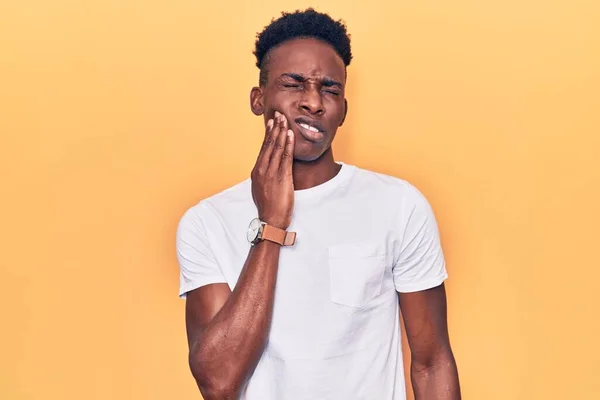 歯の痛みや歯の病気のため 若いアフリカ系アメリカ人男性は痛みを伴う表情で手で口に触れるカジュアルな服を着ています 歯科医 — ストック写真