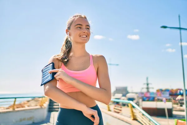 在城市里 年轻的金发女运动员用耳机锻炼身体 — 图库照片