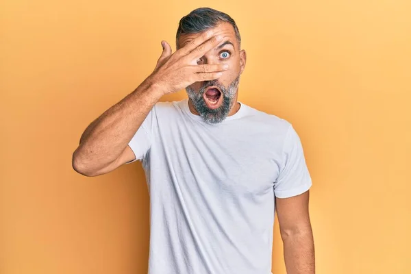 Hombre Guapo Mediana Edad Vistiendo Camiseta Blanca Casual Asomándose Shock —  Fotos de Stock