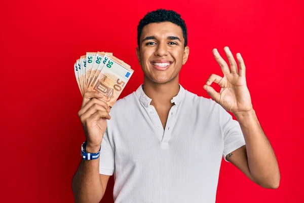 Young Arab Man Holding Euro Banknotes Doing Sign Fingers Smiling — Stock Photo, Image
