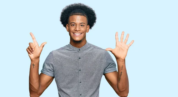 アフリカ系アメリカ人の男とアフロの髪を着てカジュアルな服を見せ 指の番号7を指摘しながら 自信と幸せ笑みを浮かべて — ストック写真