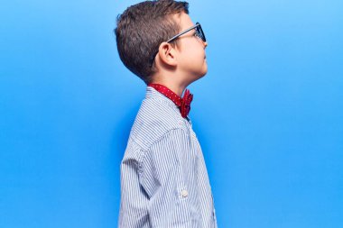 Sevimli sarışın, inek papyonu takan, gözlüklü, rahat bir görünüm takınan, kendine güvenen bir gülümsemesi olan bir çocuk.. 