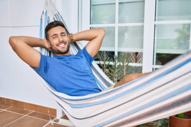 Genç İspanyol adam rahatlamış gülümsüyor mutlu bir şekilde terasta yatıyordu..