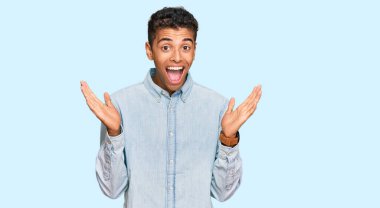 Genç, yakışıklı, Afro-Amerikan bir adam sıradan kıyafetler giyip çılgınlığı kutluyor ve başarıyı kolları açık, gözleri açık heyecanla haykırarak kutluyor. Kazanan konsept 