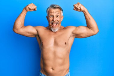 Orta yaşlı, gri saçlı, üstsüz bir adam spor yapıyor. Çılgınlığı kutluyor ve başarı için hayrete düşüyor. Gözleri açık, heyecanlı çığlıklar atıyor.. 