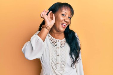 Orta yaşlı Afro-Amerikalı kadın, günlük kıyafetler giyip, sırıtarak dedikodu ve dedikoduları dinliyor. Sağırlık kavramı. 