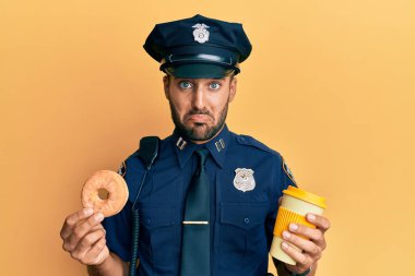 Yakışıklı İspanyol polis donut yiyor ve kahvesini içiyor. Depresyonda ve üzüntüden ağlıyor, ağlıyor ve korkuyor. hüzünlü ifade. 