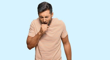 Yakışıklı, günlük kıyafetler giyen, kendini kötü hisseden ve soğuk algınlığı veya bronşitin belirtisi olarak öksüren bir İspanyol. sağlık hizmeti kavramı. 