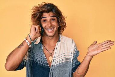 Genç İspanyol bir adam akıllı telefonda konuşuyor başarıyı mutlu bir gülümsemeyle kutluyor ve kazanan el kaldırarak ifade ediyor. 