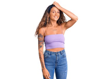 Dövmeli, sıradan kıyafetler giyen, kendine güvenen, saçlarına dokunan, el hareketi yapan çekici ve modaya uygun bir kadın. 