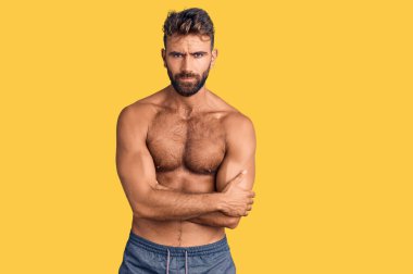 Mayo giyen genç, İspanyol bir adam. Tişörtsüz, şüpheci ve gergin. Yüzünde çapraz kollu tasvip etmeyen bir ifade var. negatif kişi. 