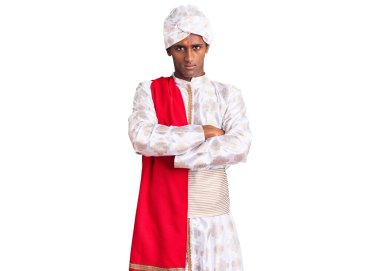 Geleneksel Sherwani elbisesi giyen Afrikalı yakışıklı bir adam şüpheci ve gergin. Yüzünde çapraz kollarla onaylamayan bir ifade var. negatif kişi. 