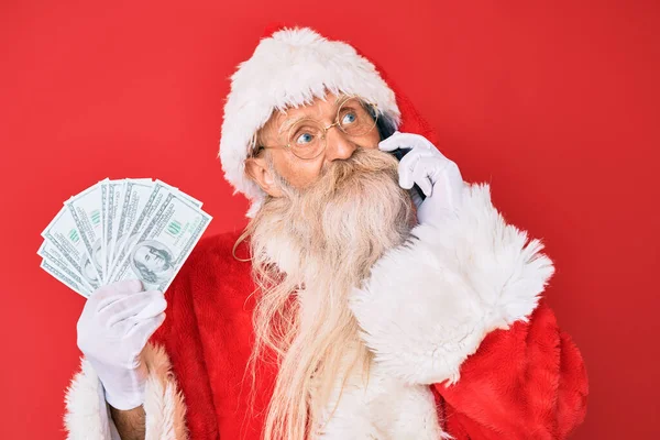 Old Senior Man Wearing Santa Claus Costume Holding Dollars Smartphone — Stock Photo, Image