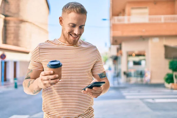Jovem Irlandês Sorrindo Feliz Usando Smartphone Beber Tirar Café Rua — Fotografia de Stock