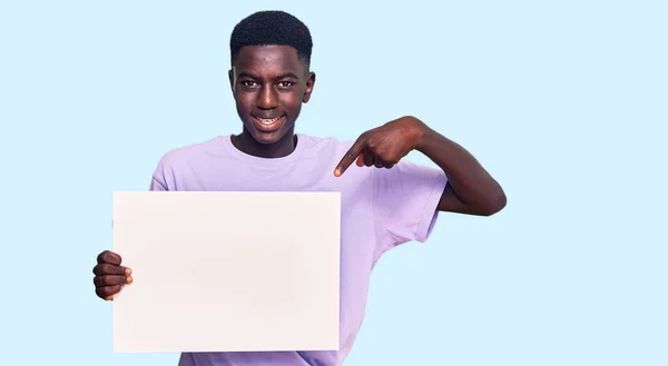 Молодий Афроамериканець Який Тримає Порожній Банер Усміхаючись Щасливий Вказуючи Рукою — стокове фото
