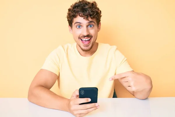 Young Caucasian Man Curly Hair Using Smartphone Sitting Table Smiling — Stock Photo, Image