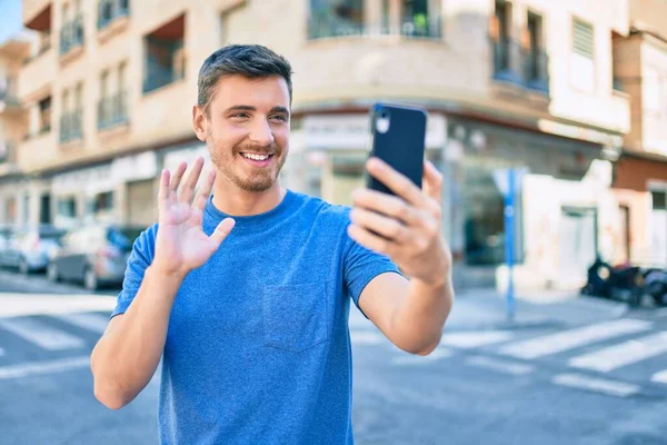 Joven Hombre Caucásico Sonriendo Feliz Haciendo Videollamada Usando Smartphone Ciudad —  Fotos de Stock