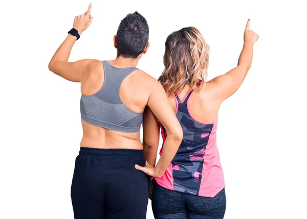 Couple Women Wearing Sportswear Posing Backwards Pointing Ahead Finger Hand — Stock Photo, Image