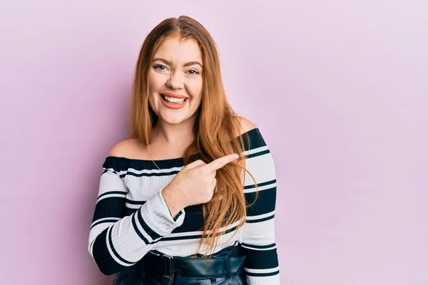 Joven Hermosa Pelirroja Vistiendo Suéter Rayas Sobre Fondo Rosa Sonriendo — Foto de Stock