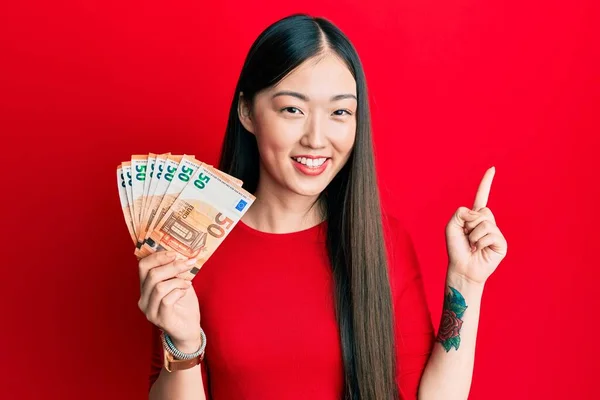 Mulher Chinesa Jovem Segurando Monte Notas Euro Sorrindo Feliz Apontando — Fotografia de Stock