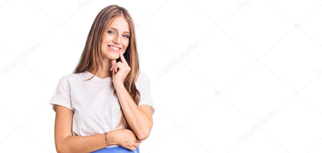 Young beautiful blonde woman wearing summer style looking confident at the camera with smile with crossed arms and hand raised on chin. thinking positive. 
