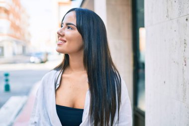 Genç İspanyol kız gülümseyerek şehirde mutlu mesut yürüyor..