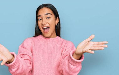 Genç Asyalı kadın, günlük kışlık süveter giyiyor. Gülümsüyor, yardım eli uzatıyor ve kabul ediyor.. 