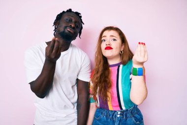 Irklar arası çiftler gündelik kıyafetler giyip İtalyan jestleri yapıyorlar. El ve parmaklarıyla kendinden emin ifade ediyorlar. 